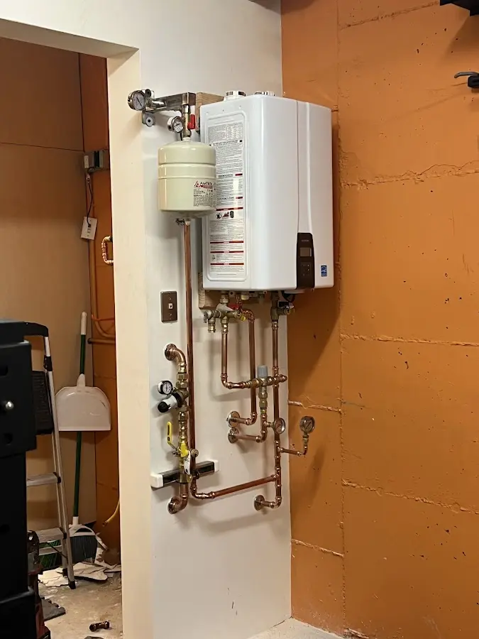 Plumbing technician inspecting water heater connections in James Island